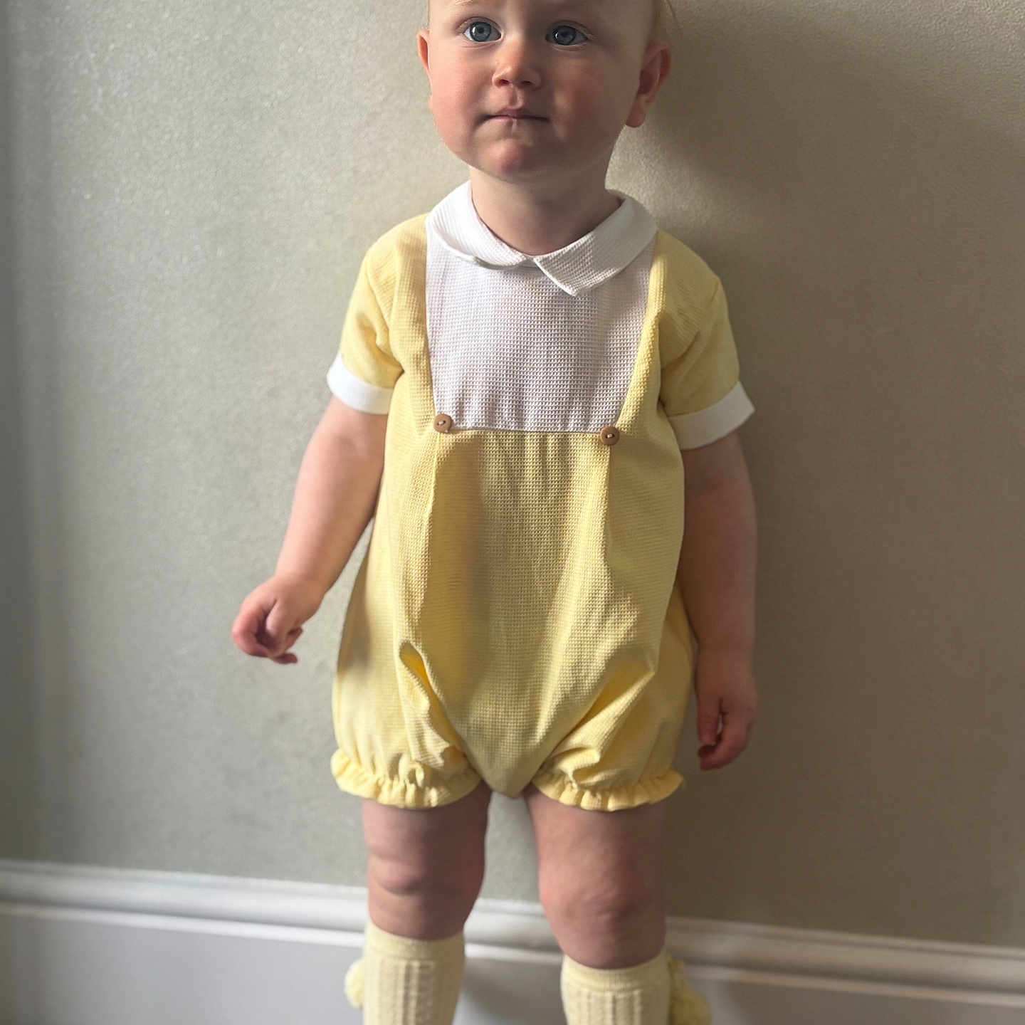 Aarron-Junior joined the competition — help win amazing prizes! baby, carpet, child, clothing, collar, cute, expression, face, feet, indoor, legs, person, portrait, shorts, socks, standing, toddler, wall, white_shoes, yellow_romper