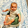 baby, infant, child, sitting, baby_seat, remote_control, rug, carpet, striped_shirt, foot, hand, floor, indoor, curious, looking_up, furniture, person, home, pattern, cute