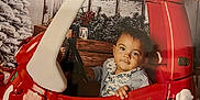James joined the competition — help win amazing prizes! child, toddler, toy_car, red, christmas_lights, holiday, winter, snow, tree, decorations, indoor, portrait, cute, baby, steering_wheel, festive, seasonal, smile, cozy, background