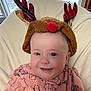 baby, child, smile, hat, reindeer, antlers, red_nose, pink_clothing, chair, indoors, window, snow, happy, face, cute, winter, holiday, infant, cozy, portrait