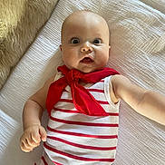 Louis participe au concours pour gagner de l'argent avec cette photo : baby, infant, child, red_scarf, striped_clothing, white_blanket, fur_texture, wide_eyes, surprised_expression, arm_outstretched, lying_down, cute, portrait, indoors, soft_light, skin, head, hand, person, toddler
