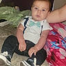 Owen is registered to the contest to win money with this photo: baby, child, infant, portrait, sitting, bow_tie, white_shirt, suspenders, jeans, sneakers, bed, blanket, bedroom, adult, clothing, fashion, blue_eyes, indoors, flash_photography, family