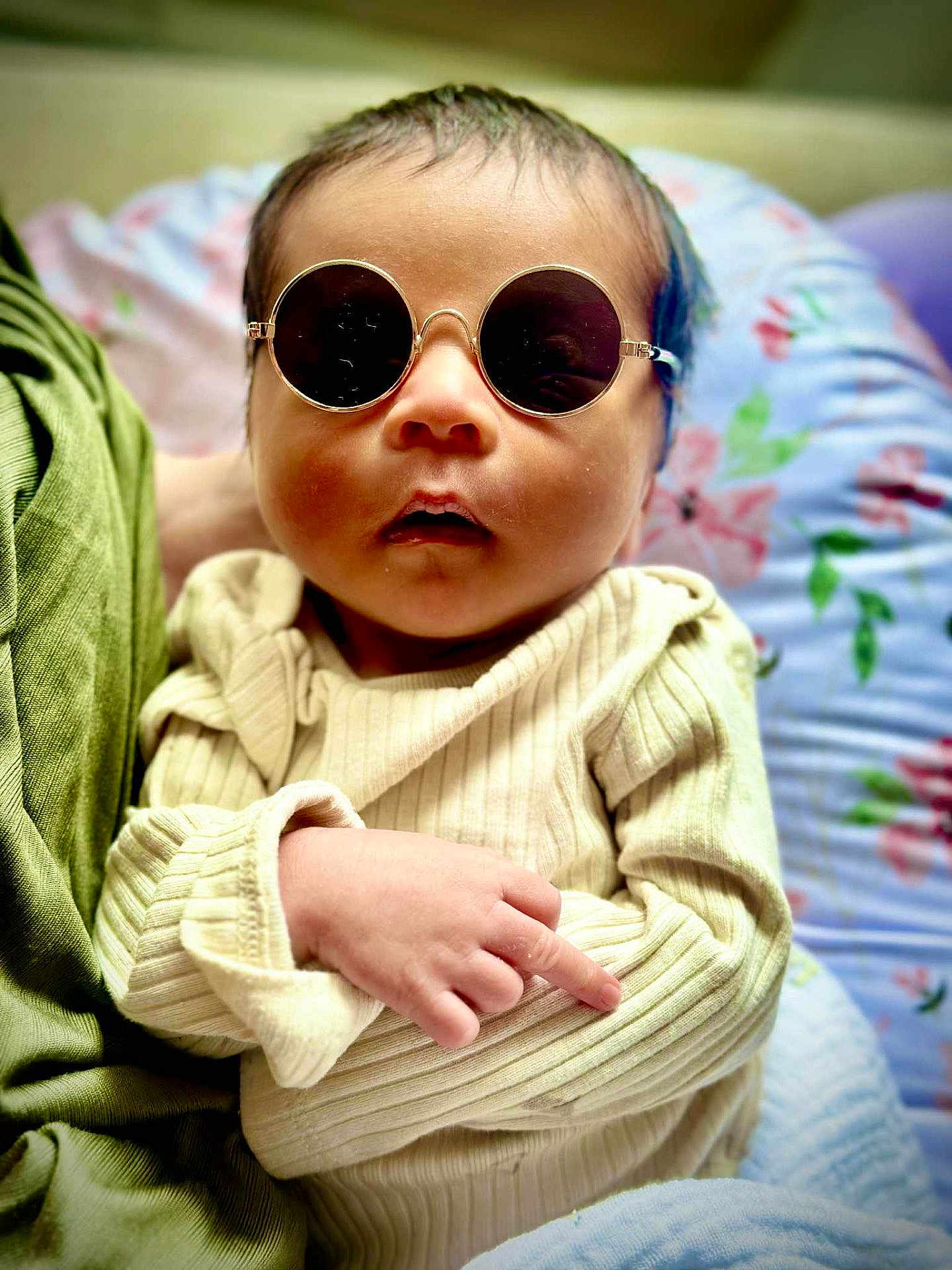 Zillion P Dorji is registered to the contest to win money with this photo: baby, sunglasses, infant, clothing, hand, face, person, cute, portrait, sitting, indoor, cozy, sleeve, fashion, young, child, resting, soft, cushion, colorful