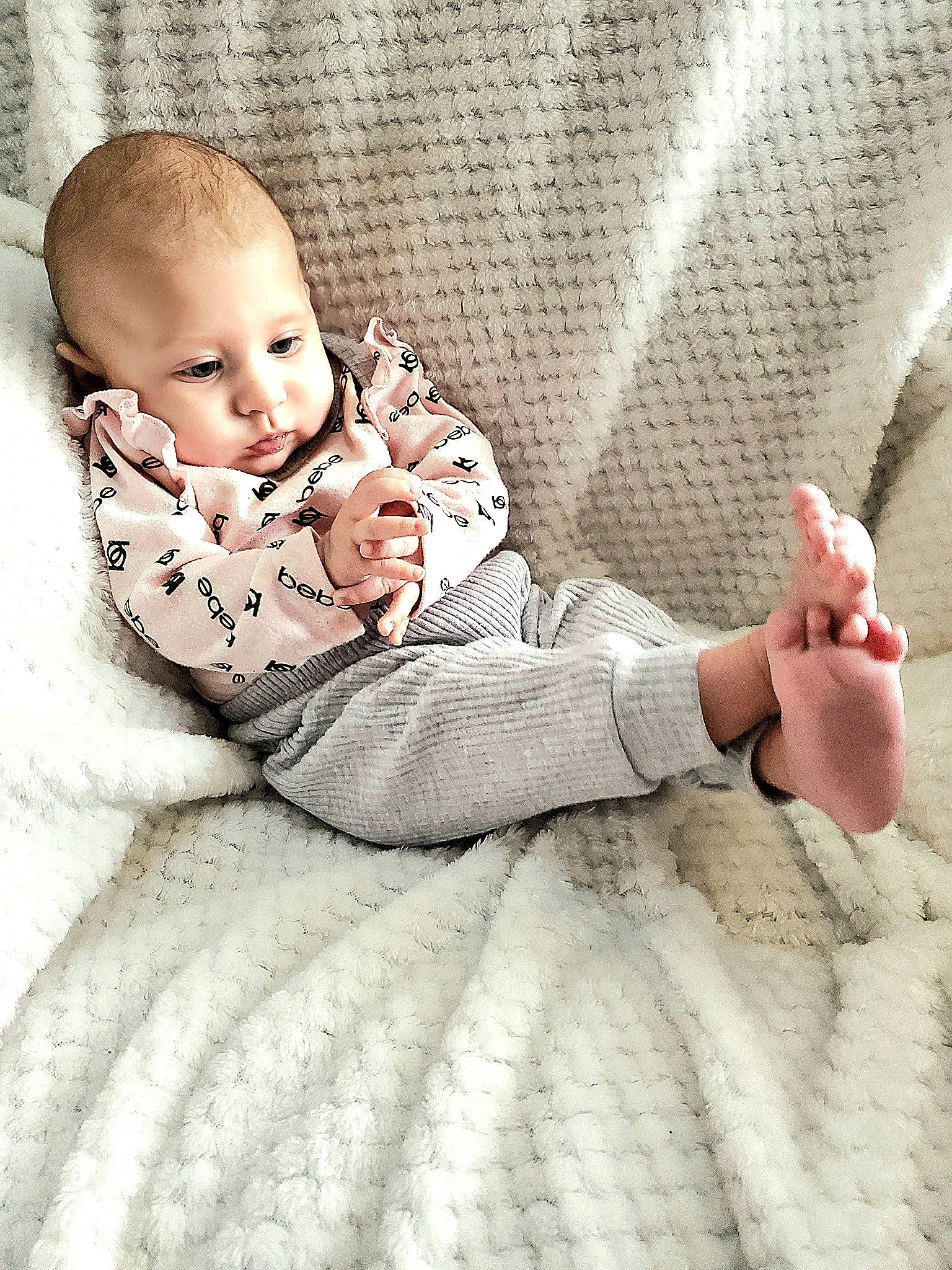 Gwen is registered to the contest to win money with this photo: arm, baby, baby_toddler_clothing, child, comfort, finger, flooring, fur, gesture, happy, human_leg, linens, mammal, person, room, sitting, skin, sleeve, textile, toddler