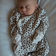 Talya a rejoint le concours — aidez-le/la à gagner de superbes lots ! baby, newborn, sleeping, infant, onesie, leopard_print, mittens, soft, blanket, cozy, clothing, peaceful, face, head, person, cute, resting, indoor, child, portrait