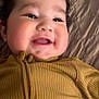 Lilith Sorrow joined the competition — help win amazing prizes! baby, child, smile, face, curly_hair, cheeks, yellow_clothing, ribbed_fabric, lying_down, quilted_bedspread, happy, infant, cute, closeup, indoors, soft_lighting, portrait, young_child, warm_colors, cozy