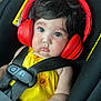 baby, child, car_seat, headphones, red_headphones, yellow_clothing, sunflower, safety_harness, black_hair, cute, infant, seatbelt, indoors, portrait, closeup, face, expression, person, young_child, child_seat