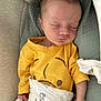 baby, sleeping, yellow_shirt, blanket, animal_print, cushion, infant, peaceful, cute, soft_lighting, indoors, portrait, child, resting, newborn, cozy, wrapped, hand, face, head