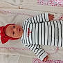 baby, infant, headband, red_bow, striped_clothing, onesie, blanket, fluffy, pink, white, face, hand, lying_down, cute, soft_texture, child, newborn, portrait, indoors, sleepwear