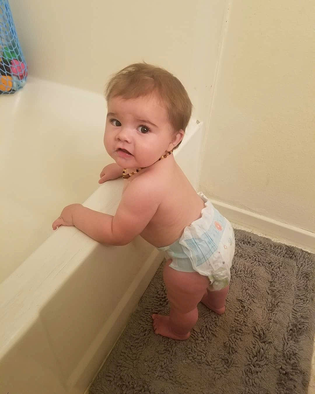 Radley is registered to the contest to win money with this photo: arm, baby, bathing, bathtub, cheek, child, diaper, eye, face, head, iris, joint, leg, person, plumbing_fixture, product, room, skin, smile, standing