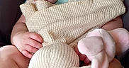 Aurelia joined the competition — help win amazing prizes! baby, infant, sleeping, car_seat, knitted_toy, stuffed_animal, bunny, blanket, clothing, portrait, indoors, travel, safety_harness, cuddling, relaxed, face, hands, feet, soft_lighting, close_up