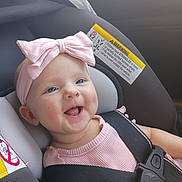 Aurelia joined the competition — help win amazing prizes! baby, child, infant, smiling, happy, portrait, car_seat, vehicle, seatbelt, safety_harness, pink_bow, pink_clothing, headband, blue_eyes, face, indoors, passenger, close_up, photography,  안전