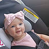 Aurelia joined the competition — help win amazing prizes! baby, infant, child, car_seat, harness, pink_bow, pink_clothing, smiling, face, portrait, blue_eyes, seated, vehicle, car_interior, safety_label, headband, indoors, close_up, happy, photograph