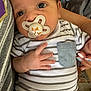 baby, pacifier, striped_onesie, hand, nails, pocket, face, closeup, infant, person, holding, cute, curious, indoor, skin, eyes, fingers, clothing, adult_hand, comfort