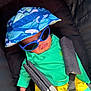 baby, child, sunglasses, hat, car_seat, seat_belt, sunhat, blue, green, yellow, clothing, infant, young_child, cute, outdoor, sun_protection, casual, relaxed, portrait, person