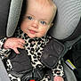 baby, child, car_seat, blue_eyes, leopard_print, clothing, seat_belt, infant, sitting, portrait, cute, smile, hand, head, face, padded, safety, indoor, person, closeup