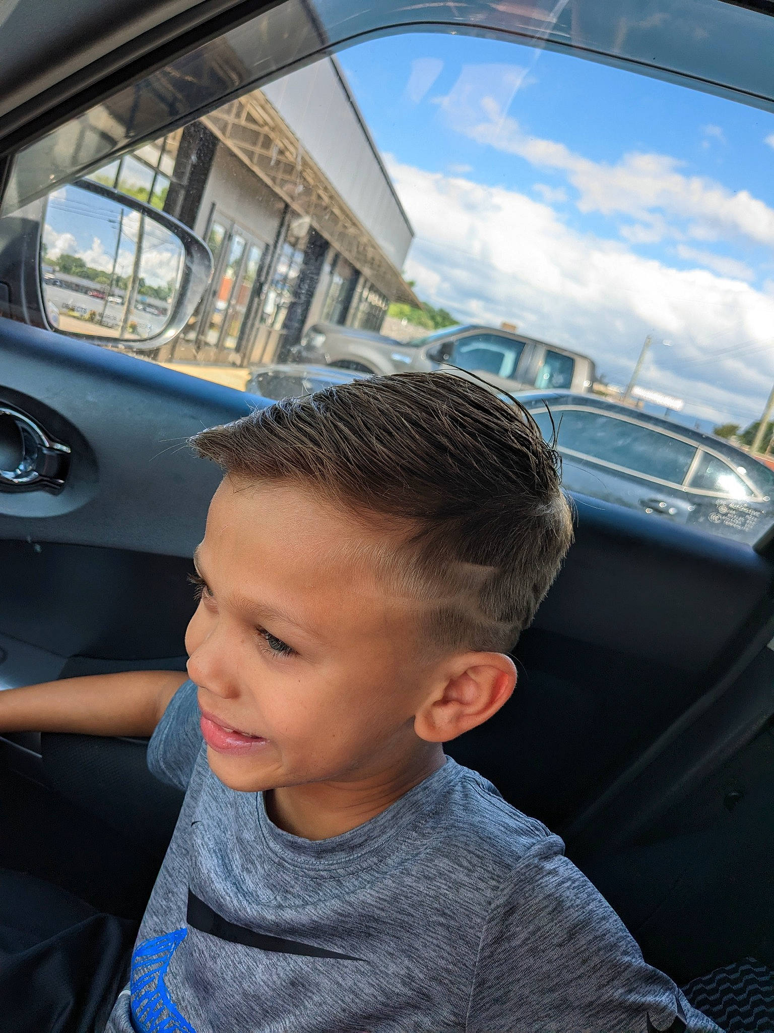 Landon is registered to the contest to win money with this photo: auto_part, automotive_design, automotive_exterior, automotive_lighting, automotive_tire, bumper, child, cloud, cool, electric_blue, family_car, flash_photography, hood, motor_vehicle, person, sky, steering_wheel, toddler, travel, vehicle_door