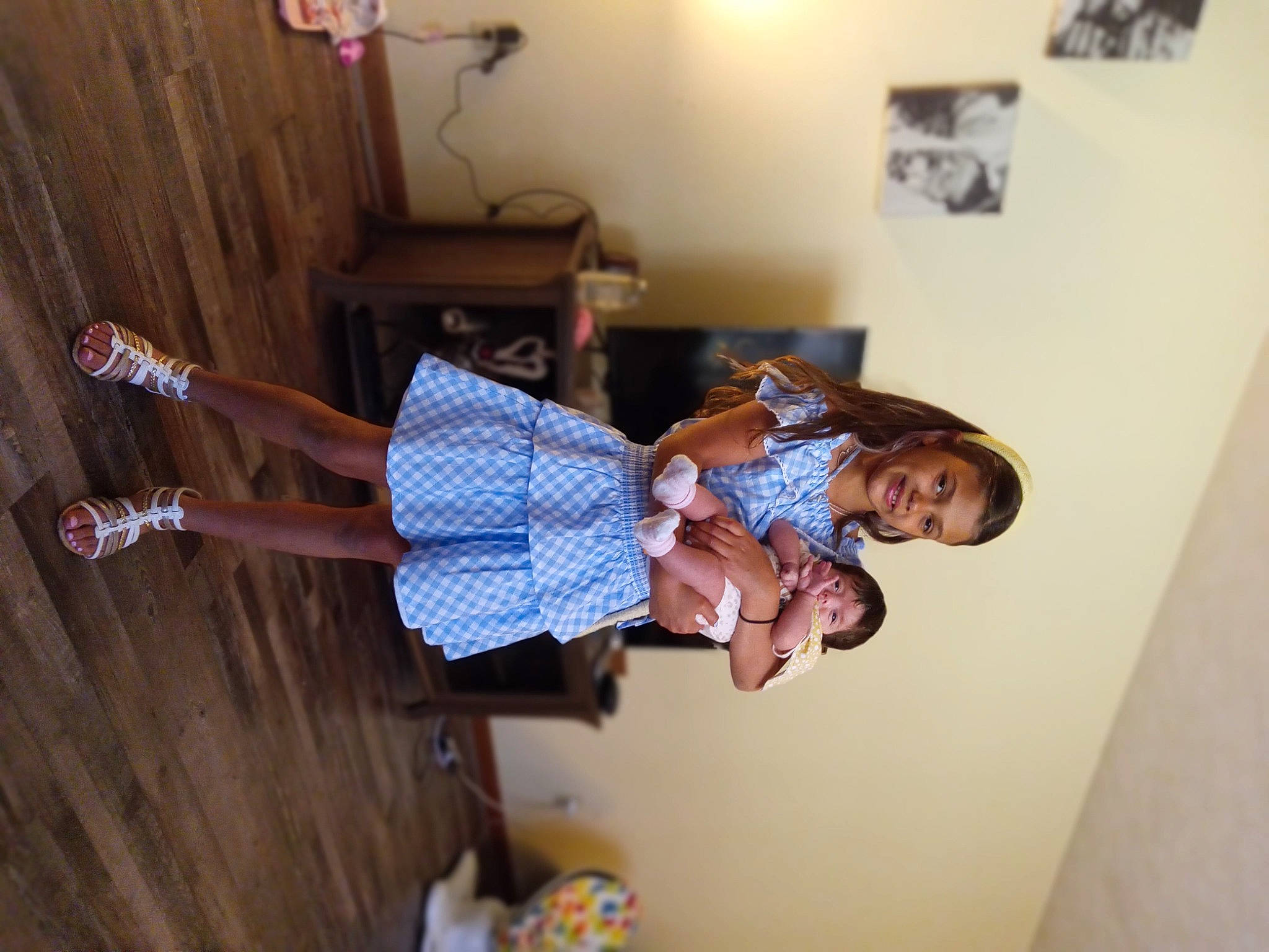 Layla is registered to the contest to win money with this photo: child, curtain, elbow, flooring, fun, happy, hardwood, human_leg, joy, pattern, person, picture_frame, room, thigh, varnish, wood, wrist