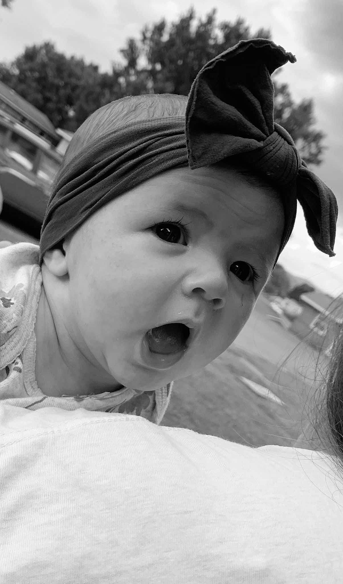 Averie is registered to the contest to win money with this photo: baby, black_and_white, cap, cheek, child, close_up, flash_photography, fun, gesture, grass, happy, hat, headwear, iris, lip, monochrome, monochrome_photography, nose, person, skin