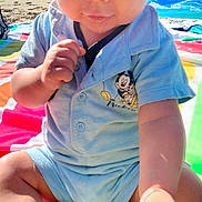 Marvynn participe au concours pour gagner de l'argent avec cette photo : baby, child, beach, sunlight, hat, blue_outfit, ball, sand, towel, cute, playful, colorful, sitting, outdoor, focused, summer, vacation, toy, portrait, closeup