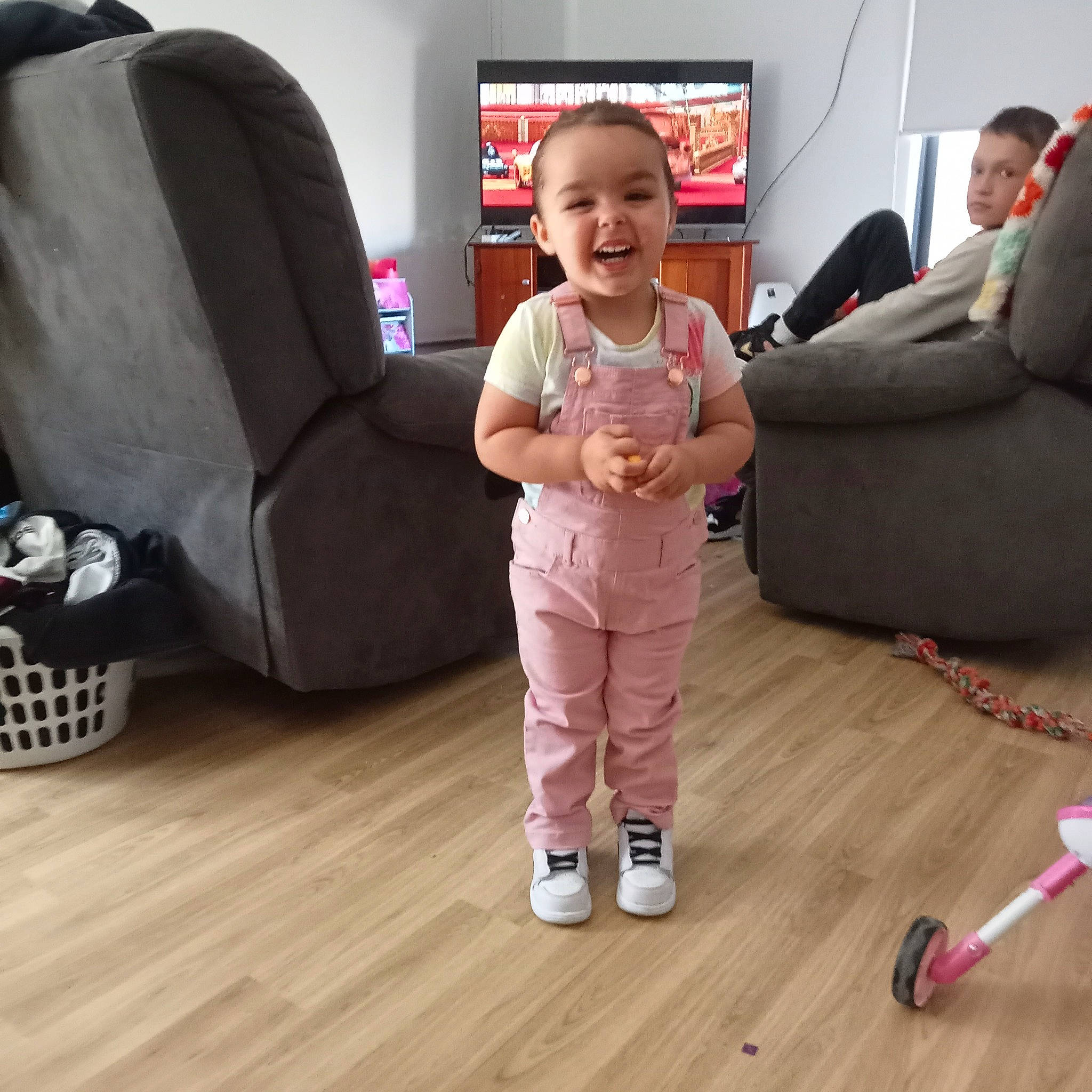 Stephanie is registered to the contest to win money with this photo: baby, baby_toddler_clothing, child, comfort, couch, face, floor, flooring, fun, hardwood, joy, leg, living_room, person, product, sleeve, smile, television, thumb, toddler