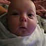 baby, close_up, face, infant, wrapped, white_cloth, wide_eyes, cozy, blanket, soft_lighting, indoor, person, cute, portrait, newborn, expression, child, head, skin, sleepy