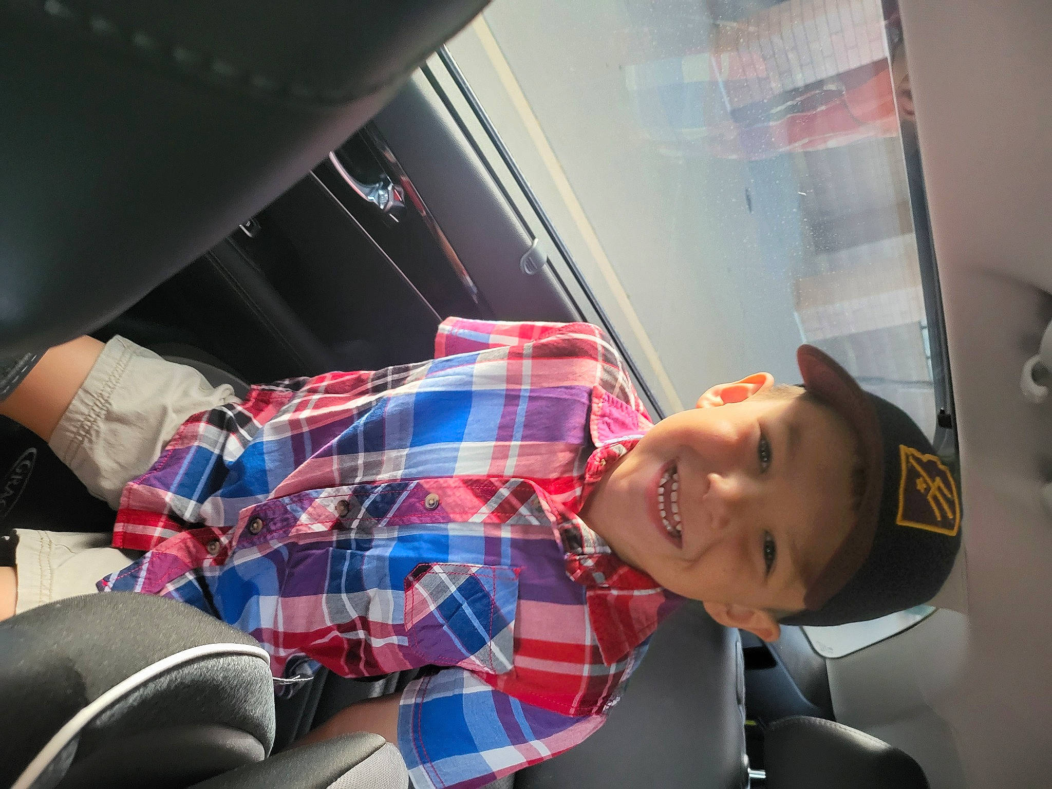 Jacob is registered to the contest to win money with this photo: auto_part, automotive_design, automotive_lighting, car_seat, comfort, elbow, eyewear, family_car, fun, headwear, human_leg, joy, knee, luxury_vehicle, motor_vehicle, pattern, person, plaid, smile, tartan