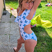 Taïna participe au concours pour gagner de l'argent avec cette photo : child, swimsuit, outdoor, grass, pose, playful, garden, backyard, toy, barefoot, path, nature, summer, greenery, person, young, casual, sunlight, fun, butterfly_pattern