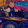 Érizio participe au concours pour gagner de l'argent avec cette photo : activity, amusement_ride, background, bike, car, child, clothing, colorful, entertainment, face, fun, indoor, person, playful, seat, smiling, sparkles, steering_wheel, toy, young