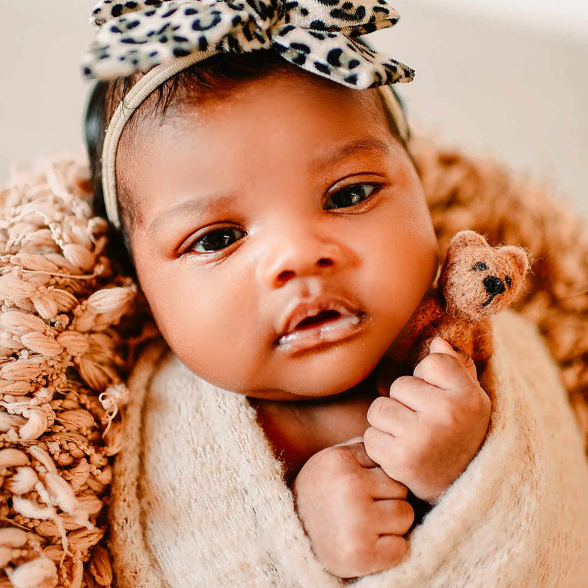 Abrianna is registered to the contest to win money with this photo: baby, blanket, bow, cheeks, close_up, cozy, cute, dark_hair, eyes, fabric, hands, headband, infant, newborn, plush_toy, portrait, soft_texture, studio_lighting, swaddle, teddy_bear