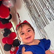 Aleska Castellano joined the competition — help win amazing prizes! balloons, blue_dress, celebration, child, colorful, cute, decorations, face, festive, happy, indoor, joyful, party, person, portrait, red_headband, silver_streamers, smiling, toddler, young_child