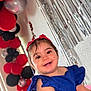 balloons, blue_dress, celebration, child, colorful, cute, decorations, face, festive, happy, indoor, joyful, party, person, portrait, red_headband, silver_streamers, smiling, toddler, young_child