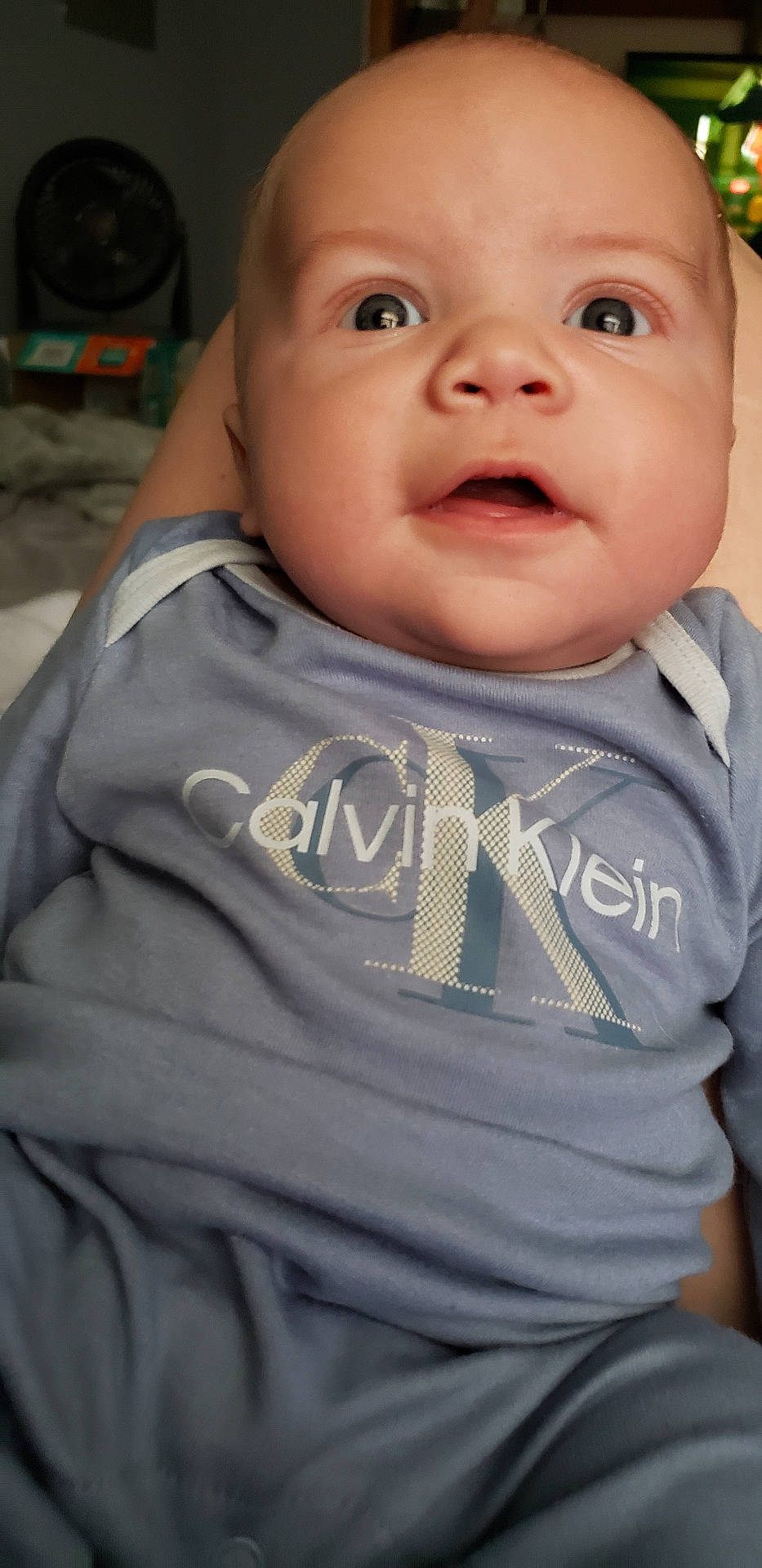 King is registered to the contest to win money with this photo: applique, baby, bodypart, clothing, face, finger, hand, head, knitwear, longsleeve, newborn, pants, person, photography, portrait, shirt, sleeve, sweater, sweatshirt, t_shirt