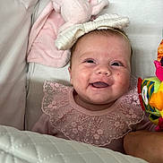 Marnie-Mai joined the competition — help win amazing prizes! baby, smiling, pink_clothing, headband, bow, lace, blanket, toy, infant, cute, happy, face, person, lying_down, soft, comfort, child, indoors, closeup, portrait
