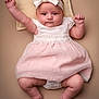 Marnie-Mai is registered to the contest to win money with this photo: arms_up, baby, barefoot, bow, child, chubby, cute, dress, headband, indoors, infant, legs, lying_down, pillow, pink, portrait, skin, soft_lighting, toes, white