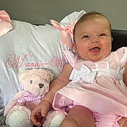 Marnie-Mai joined the competition — help win amazing prizes! baby, child, couch, cute, decoration, fabric, happy, home_interior, infant, lace, person, pillow, pink_dress, plush, portrait, ribbon, sitting, smiling, soft_toy, teddy_bear