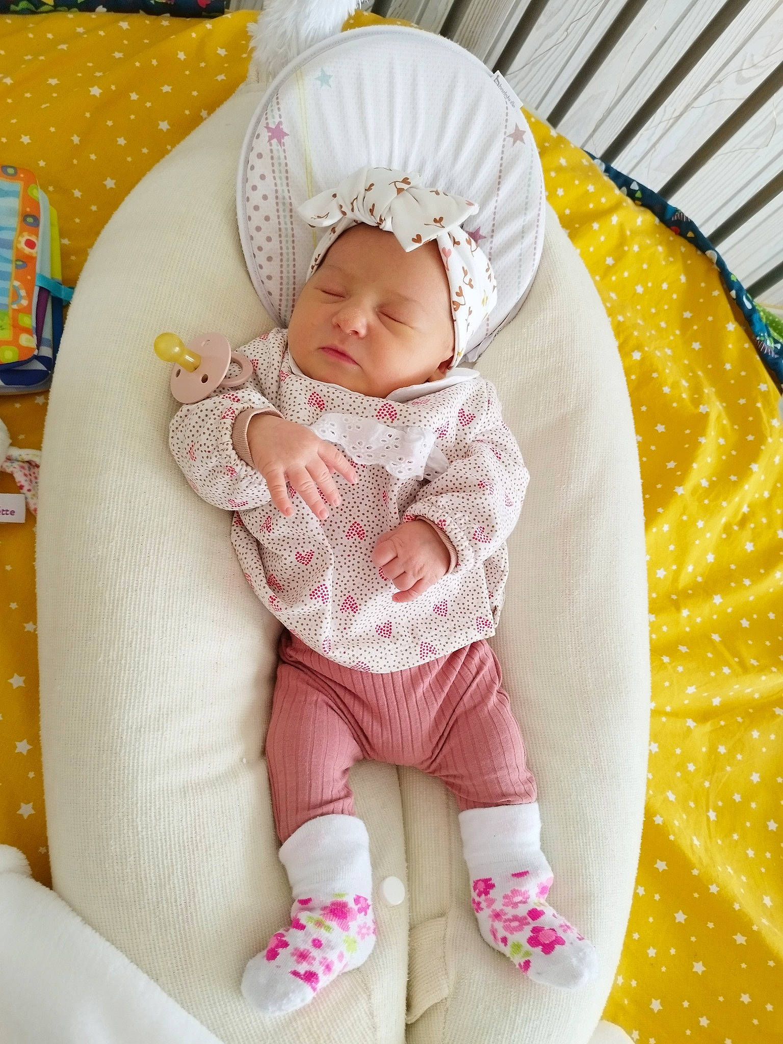 Ella participe au concours pour gagner de l'argent avec cette photo : baby, baby_carriage, baby_products, baby_safety, baby_sleeping, baby_toddler_clothing, cheek, comfort, eye, hand, headwear, lap, linens, pattern, person, pink, sitting, skin, sleeve, sock