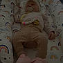 baby, sleeping, infant, clothing, pacifier, blanket, rainbow_pattern, soft_toys, footwear, bed, cozy, cute, child, person, pink, knitwear, sleep, rest, indoors, comfort