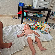 Fabrizio participe au concours pour gagner de l'argent avec cette photo : baby, blanket, diaper, floor, toy, table, printer, foot, wall, paper, colorful, indoor, child, playtime, smile, infant, person, home, plastic_toy, relaxing
