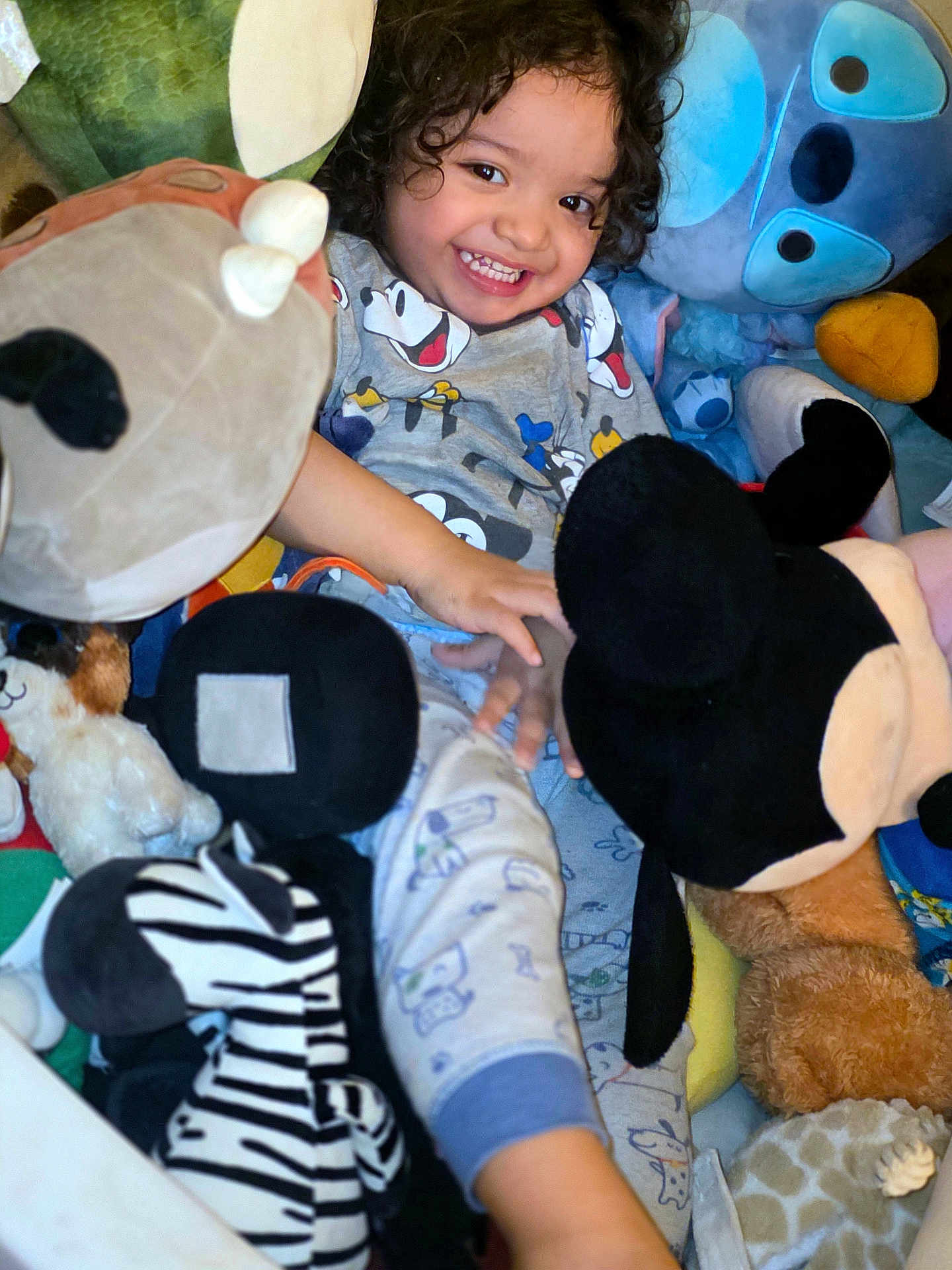 Kyrie joined the competition — help win amazing prizes! child, smiling, curly_hair, stuffed_animals, plush_toys, mickey_mouse, zebra_toy, toddler, happy, cozy, indoor, cuddly, playtime, cute, bedtime_clothes, soft_toys, colorful, joyful, portrait, young_kid