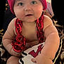 baby, child, infant, red_hat, knit_cap, red_chain, plush_toy, hand, face, eyes, cheeks, skin, cute, indoor, blanket, pattern, soft_toy, football, sports_fan, smiling