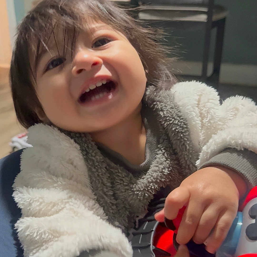 Abel Landaverde joined the competition — help win amazing prizes! chair, child, clothing, face, floor, furniture, hair, hand, happy, indoor, jacket, joy, kid, person, playing, room, smiling, table, toddler, toy