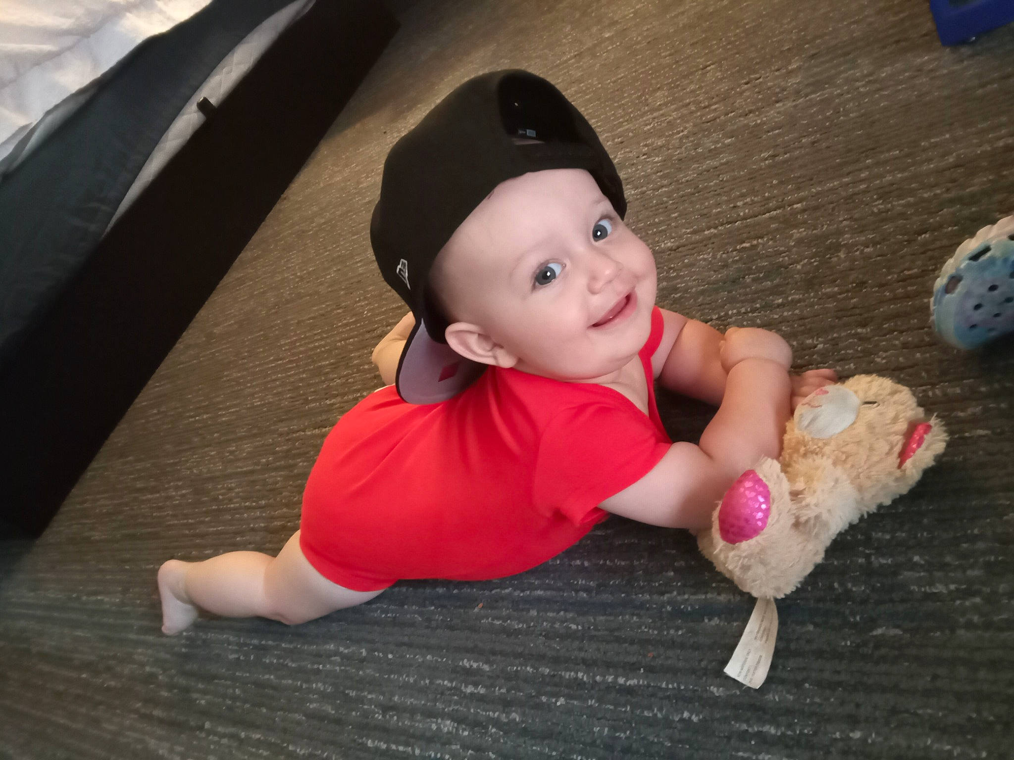 Genesis is registered to the contest to win money with this photo: baby, baby_toddler_clothing, cap, carmine, child, facial_expression, flooring, foot, fun, happy, hat, headwear, human_leg, joy, person, sitting, skin, smile, thigh, thumb