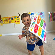 Langston joined the competition — help win amazing prizes! toddler, child, indoor, carpet, poster, colors, educational, learning, smiling, barefoot, shorts, shirt, playroom, map, numbers_chart, toy, happy, cute, boy, walking