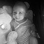 baby, baby_garment, black_and_white, child, comfort, cuddling, cute, indoors, infant, monochrome, one_piece_clothing, person, plush_toy, portrait, sleepy, soft_lighting, striped_clothing, teddy_bear, toy, young