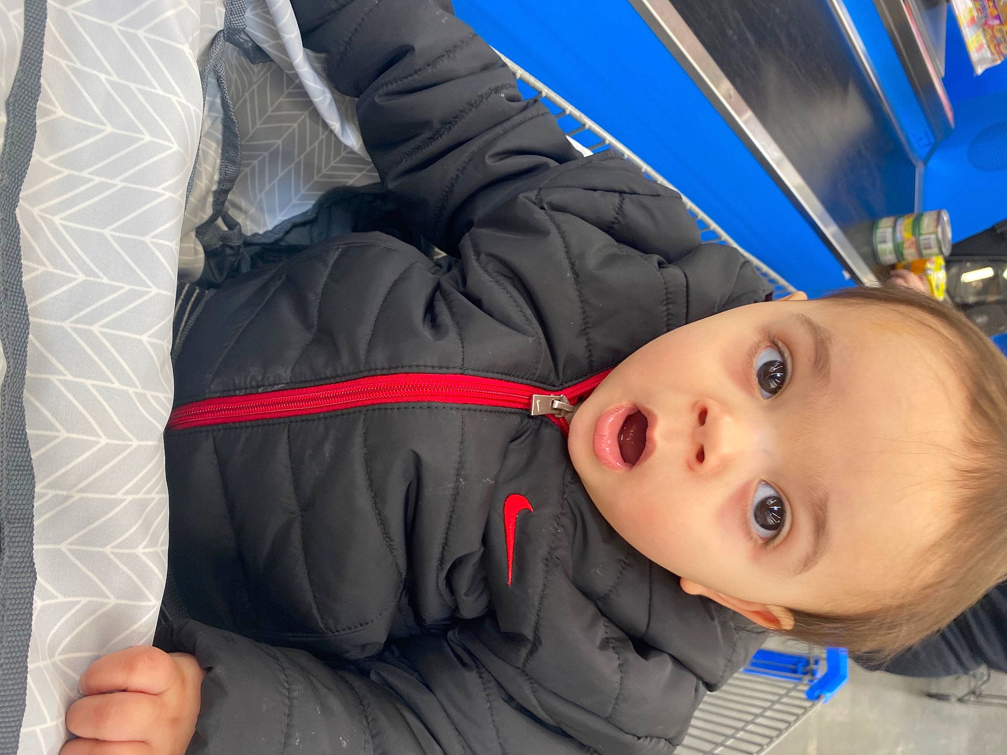 Alonzo is registered to the contest to win money with this photo: air_travel, auto_part, baby, blue, car_seat, child, comfort, electric_blue, fun, human_body, jacket, leisure, outerwear, person, personal_protective_equipment, recreation, sleeve, surprise, toddler, tree