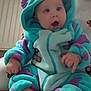 baby, child, infant, hoodie, onesie, blue, purple, soft_texture, indoor, radiator, adult_hand, carpet, curtains, light, expression, cute, warm, cozy, foot, person