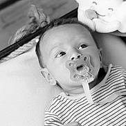 Lyenzo participe au concours pour gagner de l'argent avec cette photo : baby, pacifier, basket, plush_toy, striped_clothing, infant, black_and_white, cute, indoors, portrait, child, face, hand, blanket, smile, soft_toy, rope, relaxing, newborn, comfort