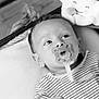 baby, pacifier, basket, plush_toy, striped_clothing, infant, black_and_white, cute, indoors, portrait, child, face, hand, blanket, smile, soft_toy, rope, relaxing, newborn, comfort