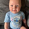 baby, infant, child, portrait, smiling, seated, blue_outfit, stitch_character, onesie, chair, cushion, indoors, close_up, face, eyes, happy, cute, casual, cozy, photography